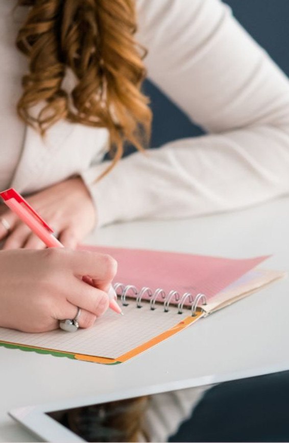 A business owner planning and writing notes at a desk